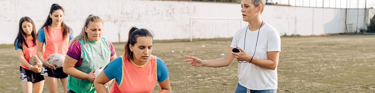 Coach with a lineup of girls playing sport